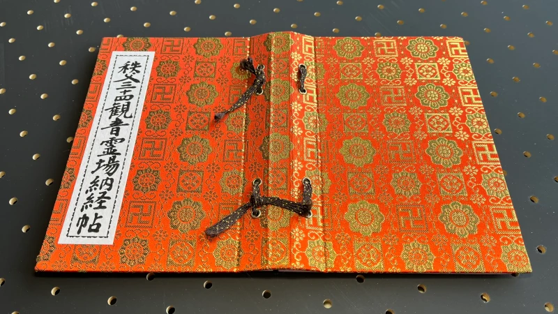 秩父札所の納経帳の綴じ紐は、墨書をしやすくするために少し緩めておくとよいことを示す案内画像。納経帳全体と、ゆとりを持たせた綴じ紐の状態を撮影